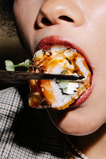 pexels-photo-8951355-8951355 Detailed close-up of a person savoring sushi using chopsticks, highlighting culinary culture.